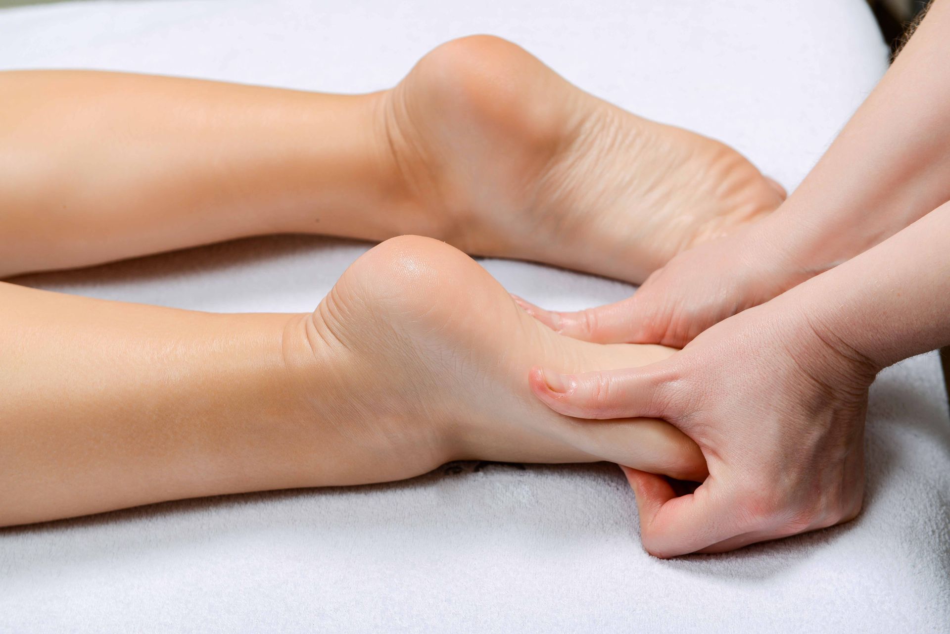 Massage therapist performing professional foot reflexology treatment at spa or wellness clinic. Massage therapist performing professional foot reflexology treatment at spa or wellness clinic.