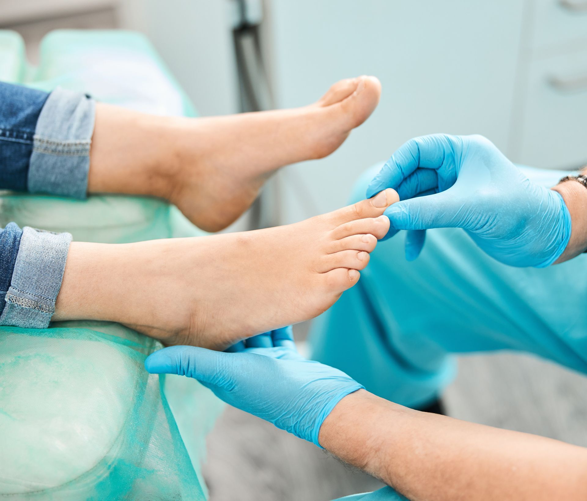 Doctor hands in blue gloves checking patient foot and ankle during orthopedic medical exam. Doctor hands in blue gloves checking patient foot and ankle during orthopedic medical exam.