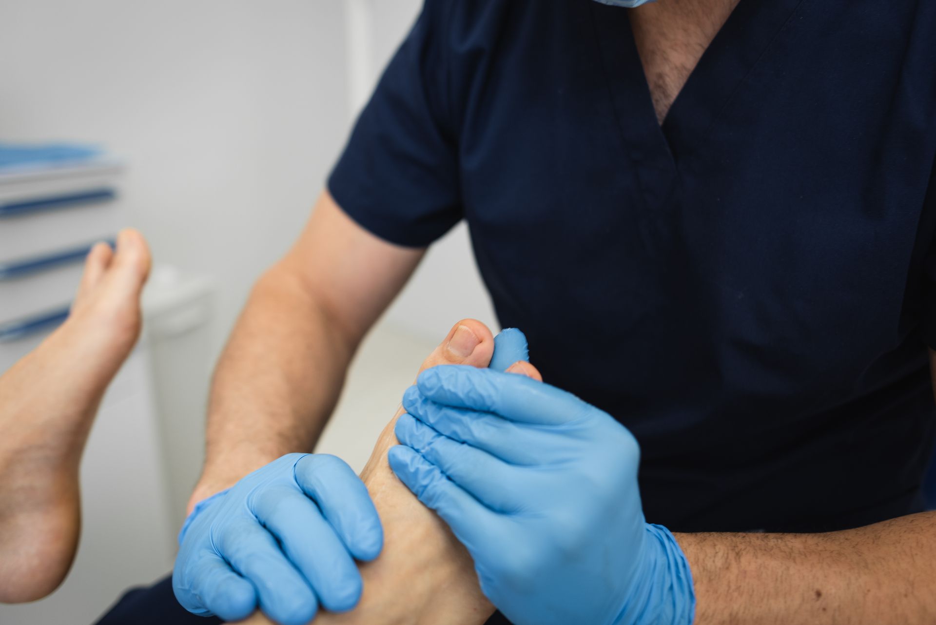 A podiatrist examines a patient’s foot during a thorough clinic consultation.
