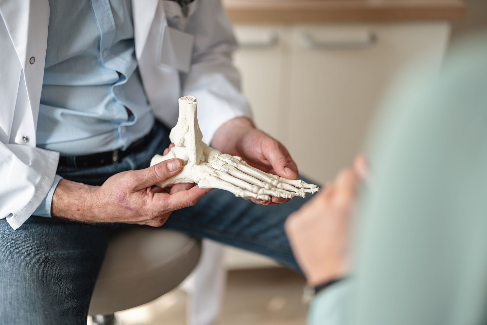 Close up of a general practitioner showing bones of a foot on a skeleton.