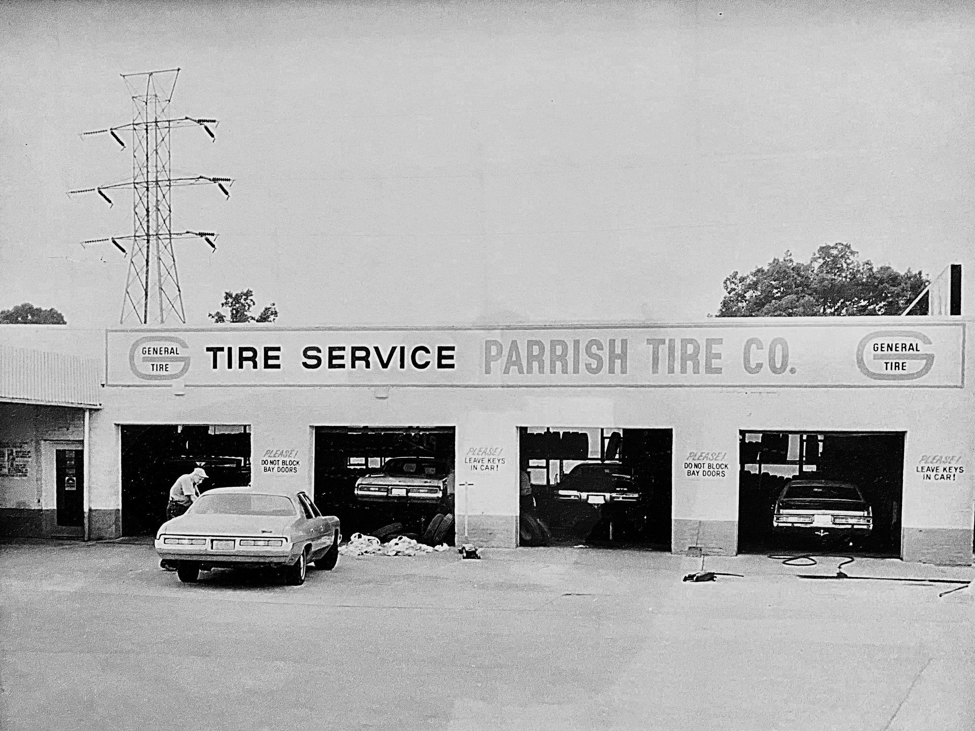 A black and white photo of a tire service parrish tire co.