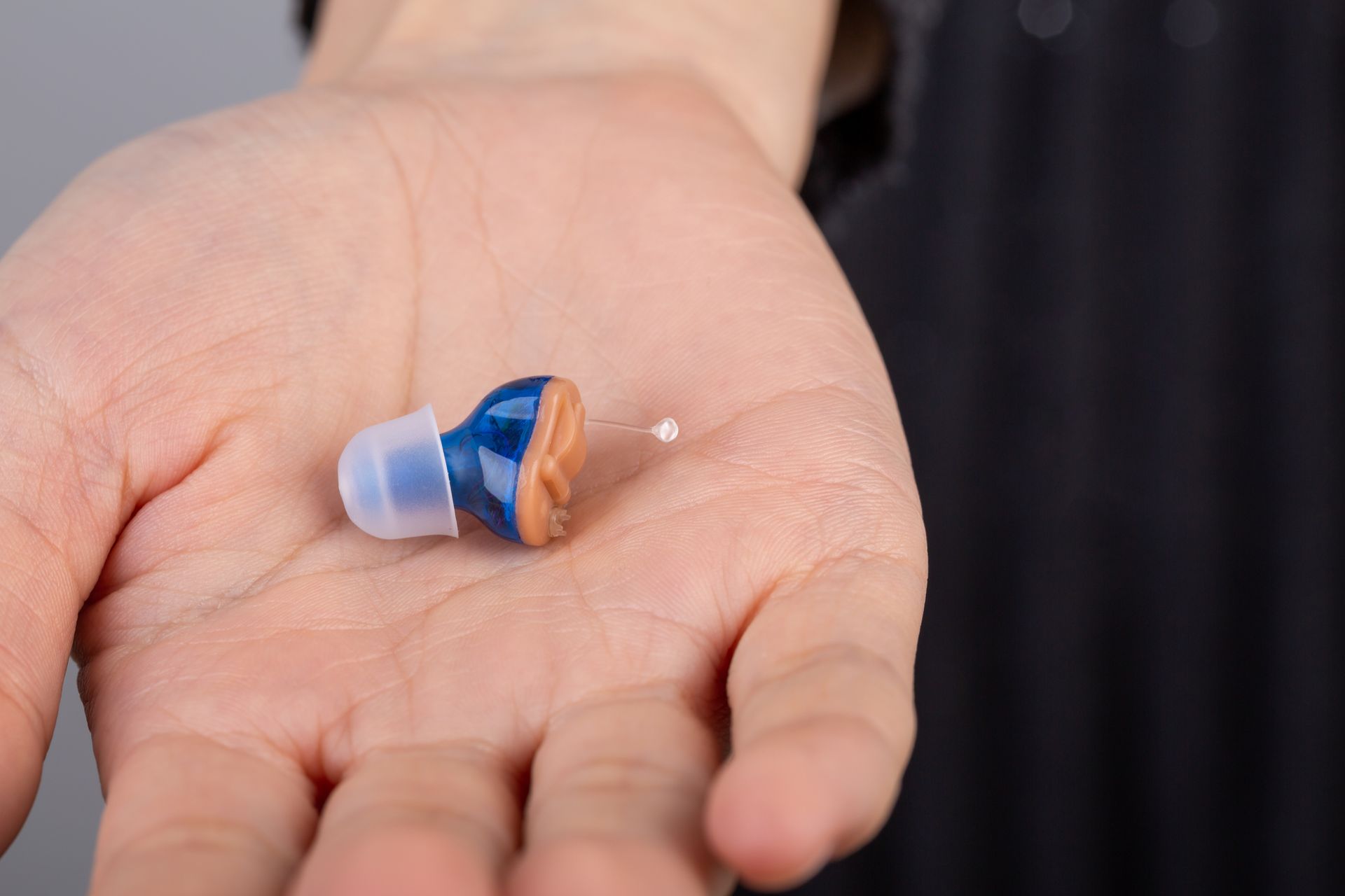 Hearing aid resting gently in woman’s hand.