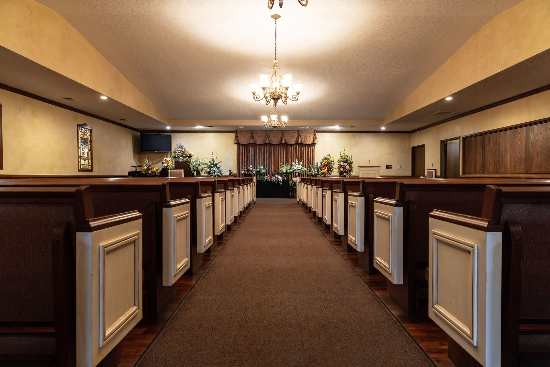 A man in a suit is sitting at a coffin at a funeral.