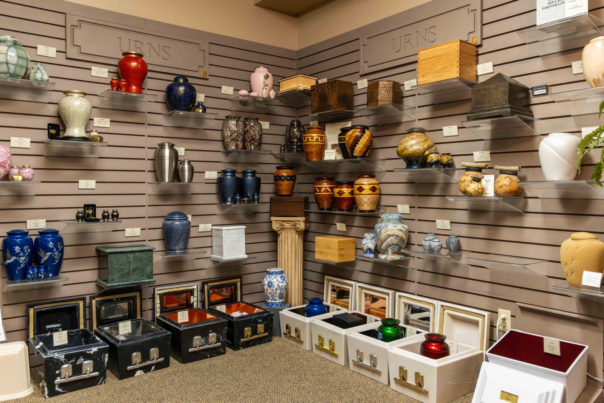 A black can is sitting on a table next to a vase of flowers.