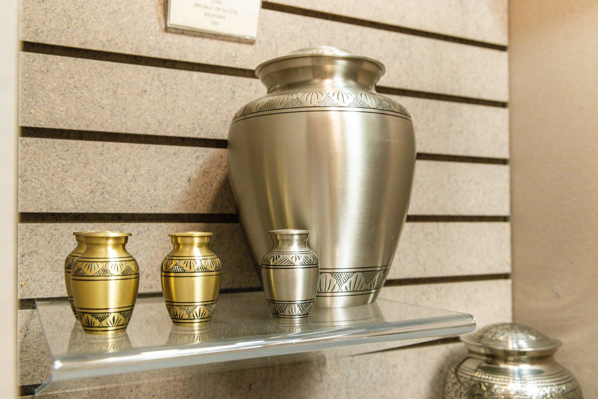 A black urn is sitting on top of a rock in the grass.