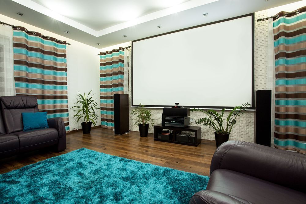 A Living Room With a Projector Screen and a Blue Rug — Garrow's TV & Antenna Services in Caloundra West, QLD