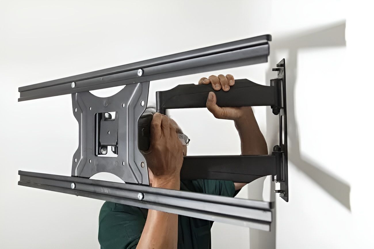 A Man is Installing a Tv Mount on a Wall — Garrow's TV & Antenna Services in Caloundra West, QLD