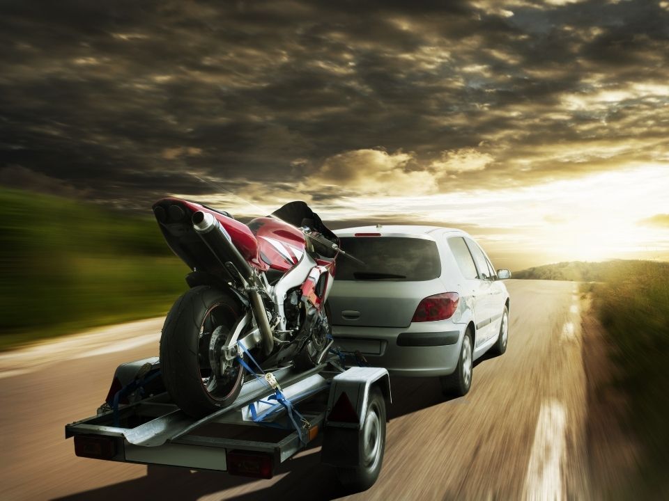 motorcycle on trailor behind car