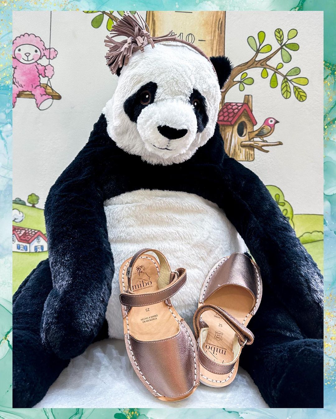 Peluche a forma di panda seduto con sandali color oro rosa, su uno sfondo stravagante.