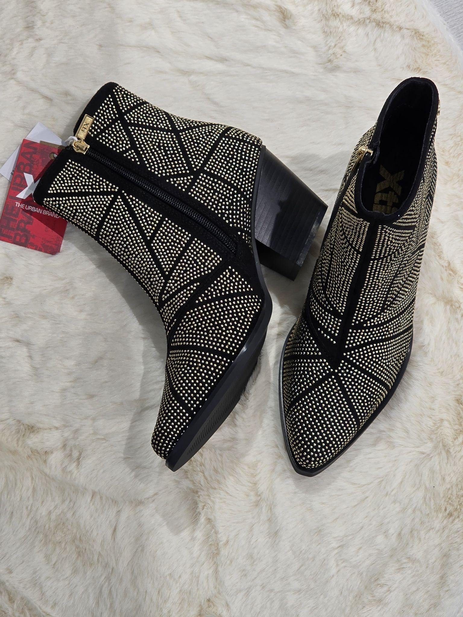 Un paio di stivaletti alla caviglia con fantasia nera e marrone chiaro e tacco spesso.