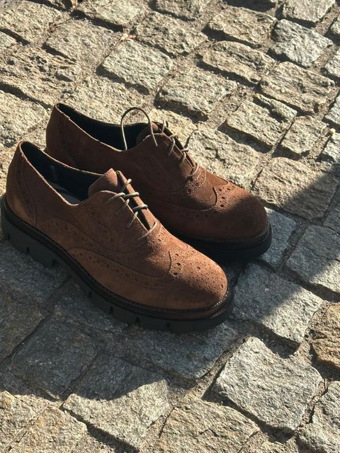 Ballerine bianche con fiocchi e cinturini alla caviglia su seta verde con conchiglie.