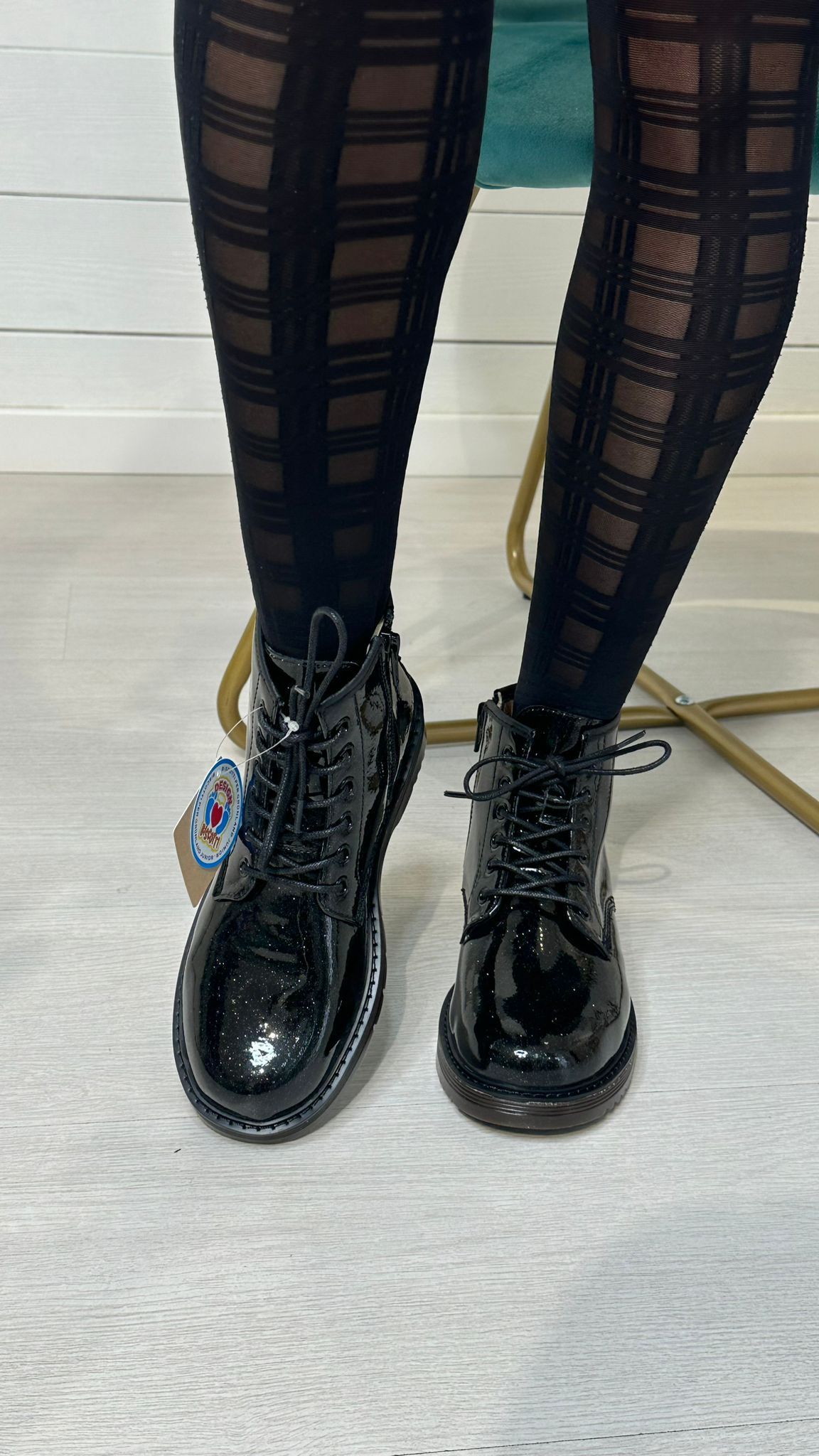 Anfibi neri in vernice e collant fantasia.