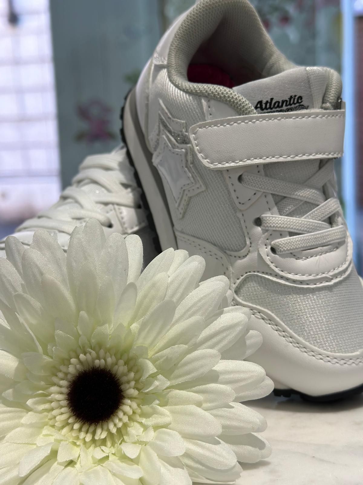 Scarpe sportive bianche con dettaglio a stella e composizione floreale.
