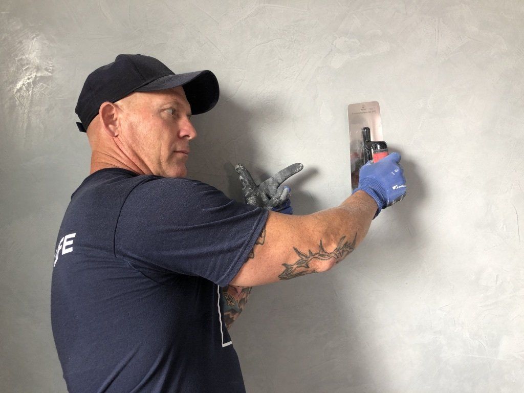 The Idaho Painter is plastering a wall with a trowel.