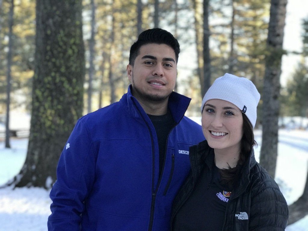 A man and a woman are posing for a picture in the snow.