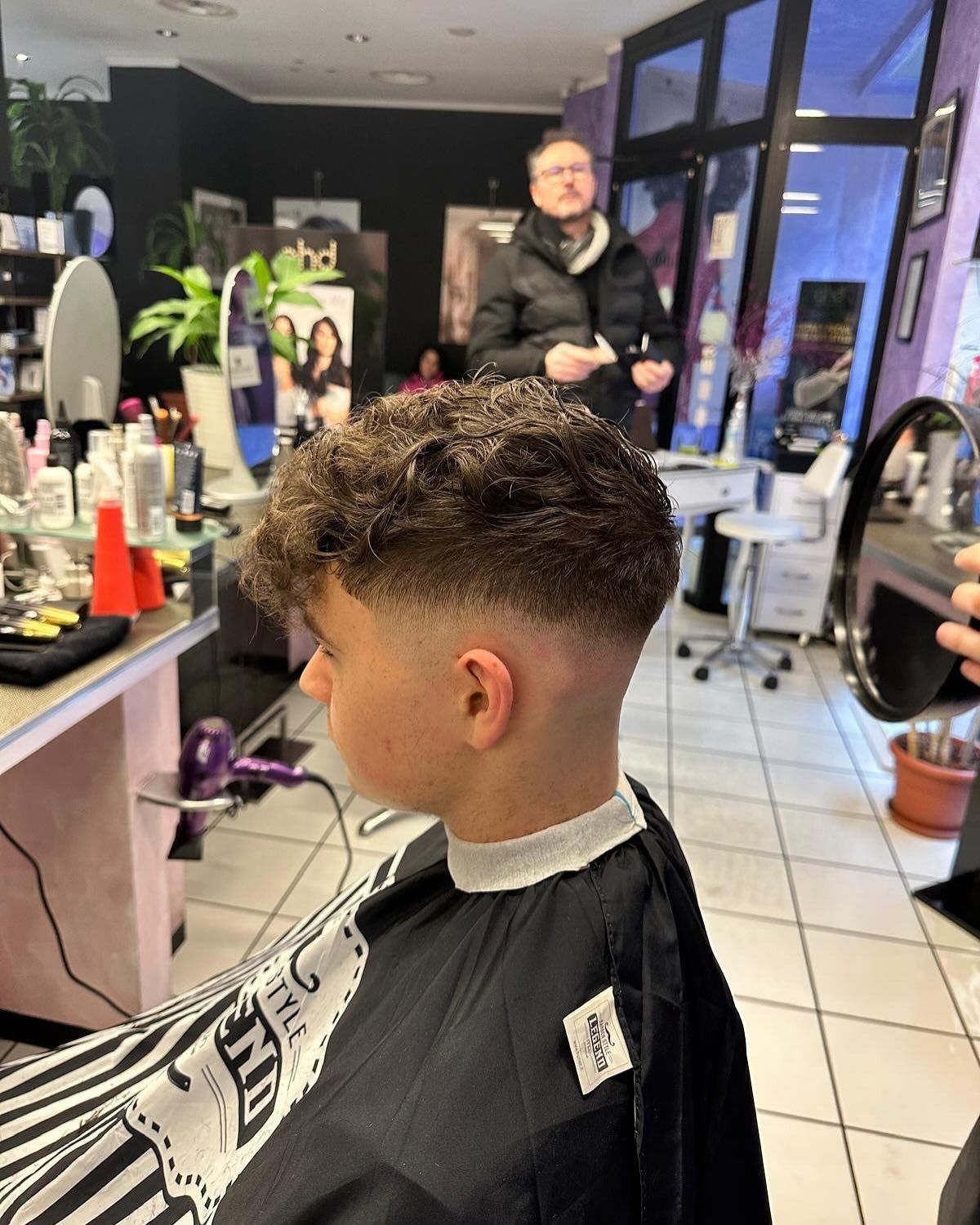 Un giovane si sta tagliando i capelli dal barbiere.