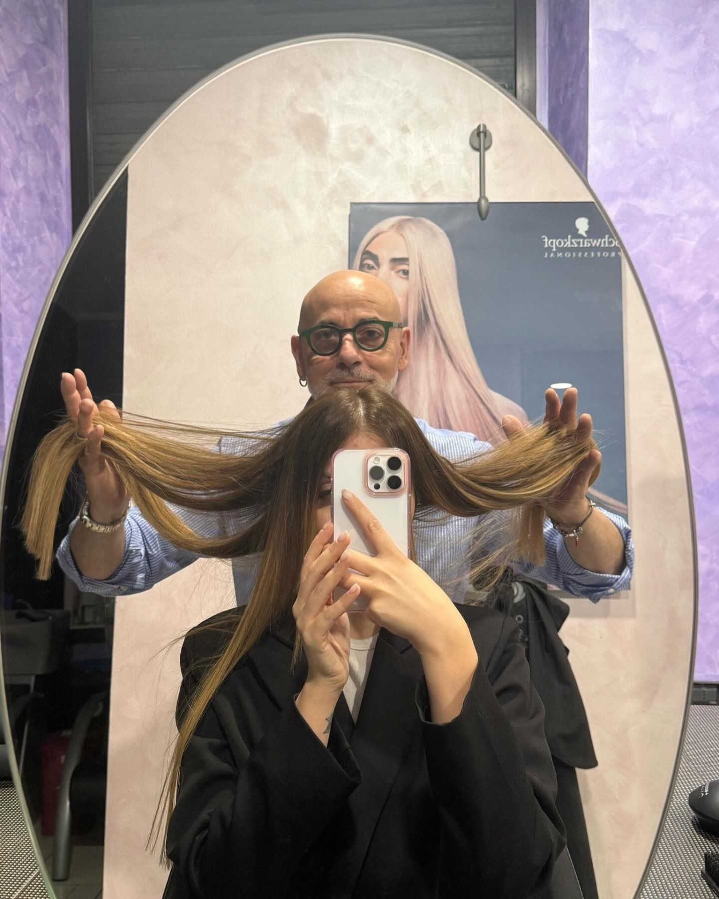 Un uomo tiene i capelli di una donna davanti a uno specchio.