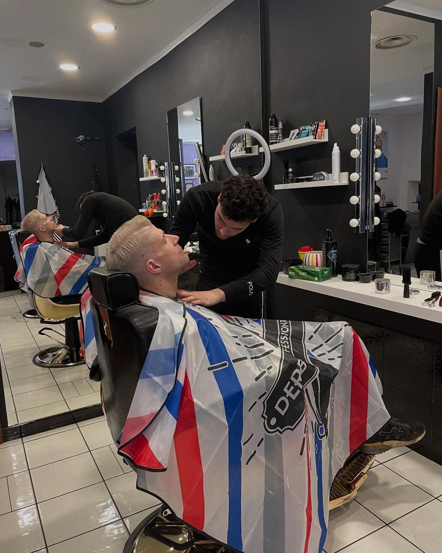 Un uomo si sta facendo tagliare i capelli da un barbiere in un negozio di barbiere.