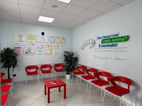 Una sala d'attesa con sedie rosse e un tavolo