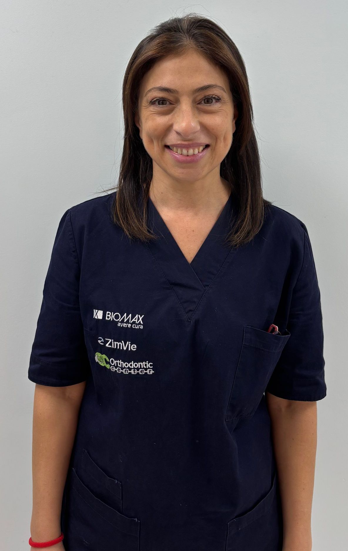 Una donna con una camice blu sorride alla telecamera.