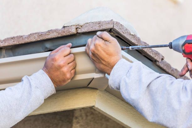Construction worker installing soffit under a roof.