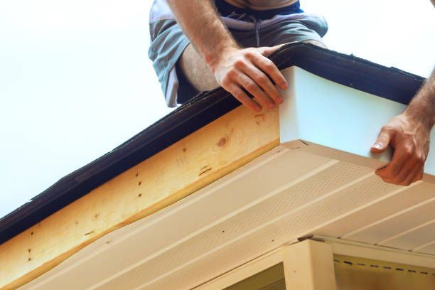 Brown roof with matching gutters and downspout on a house.