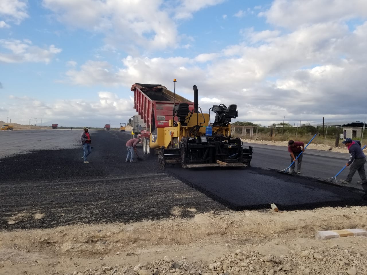 A group of construction workers are working on a road