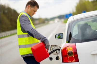 Picture of Guy with safety vest filling up car with jerry can on the side of the road