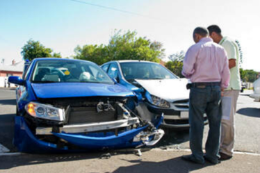 Picture of Two Guys looking at the front of their cars that have crashed and have damage