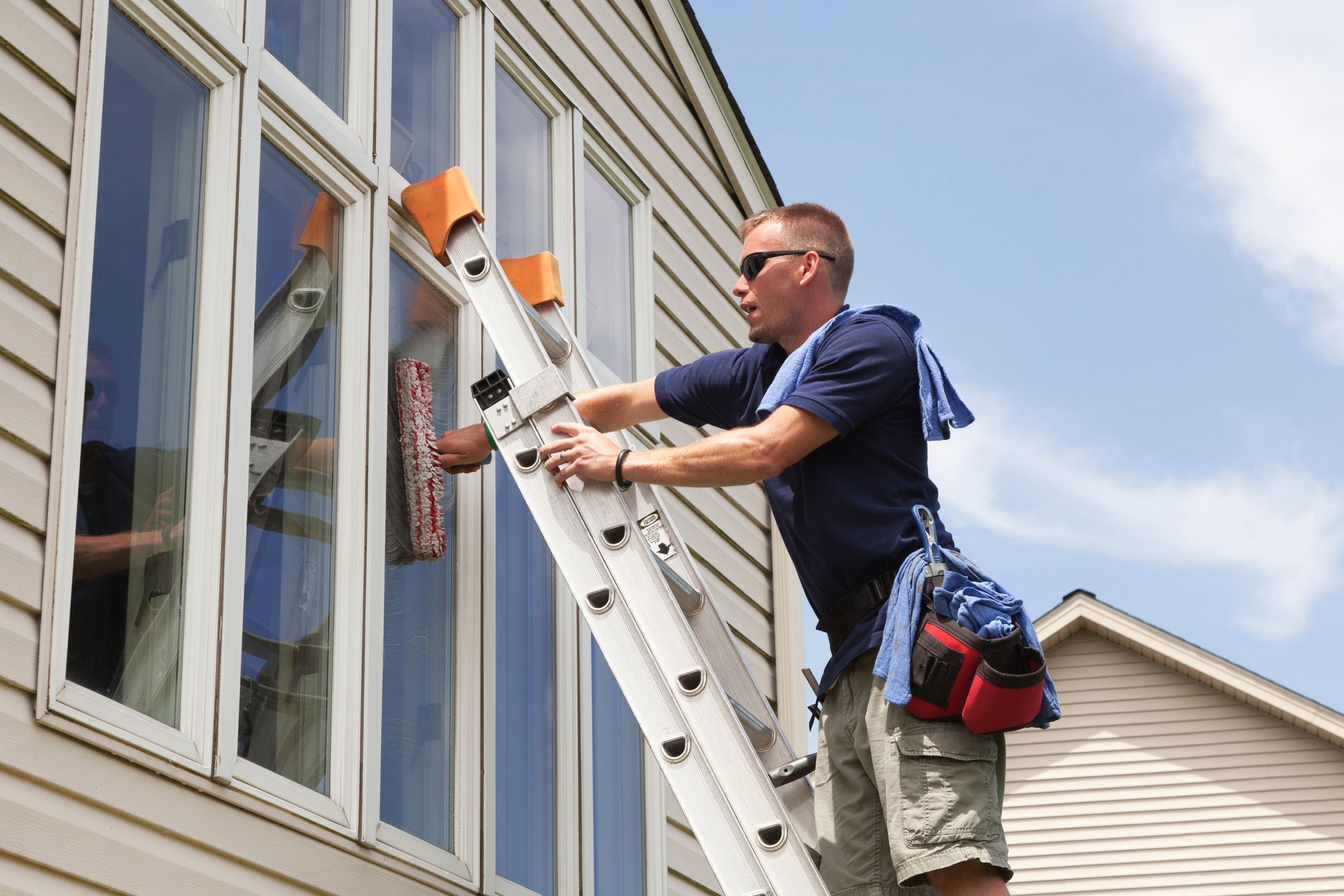 A worker is cleaning a window.