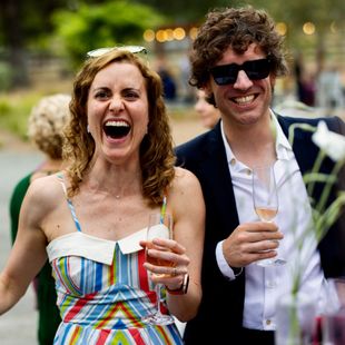 Guests laughing at magic performed by David Martinez at an outdoor event