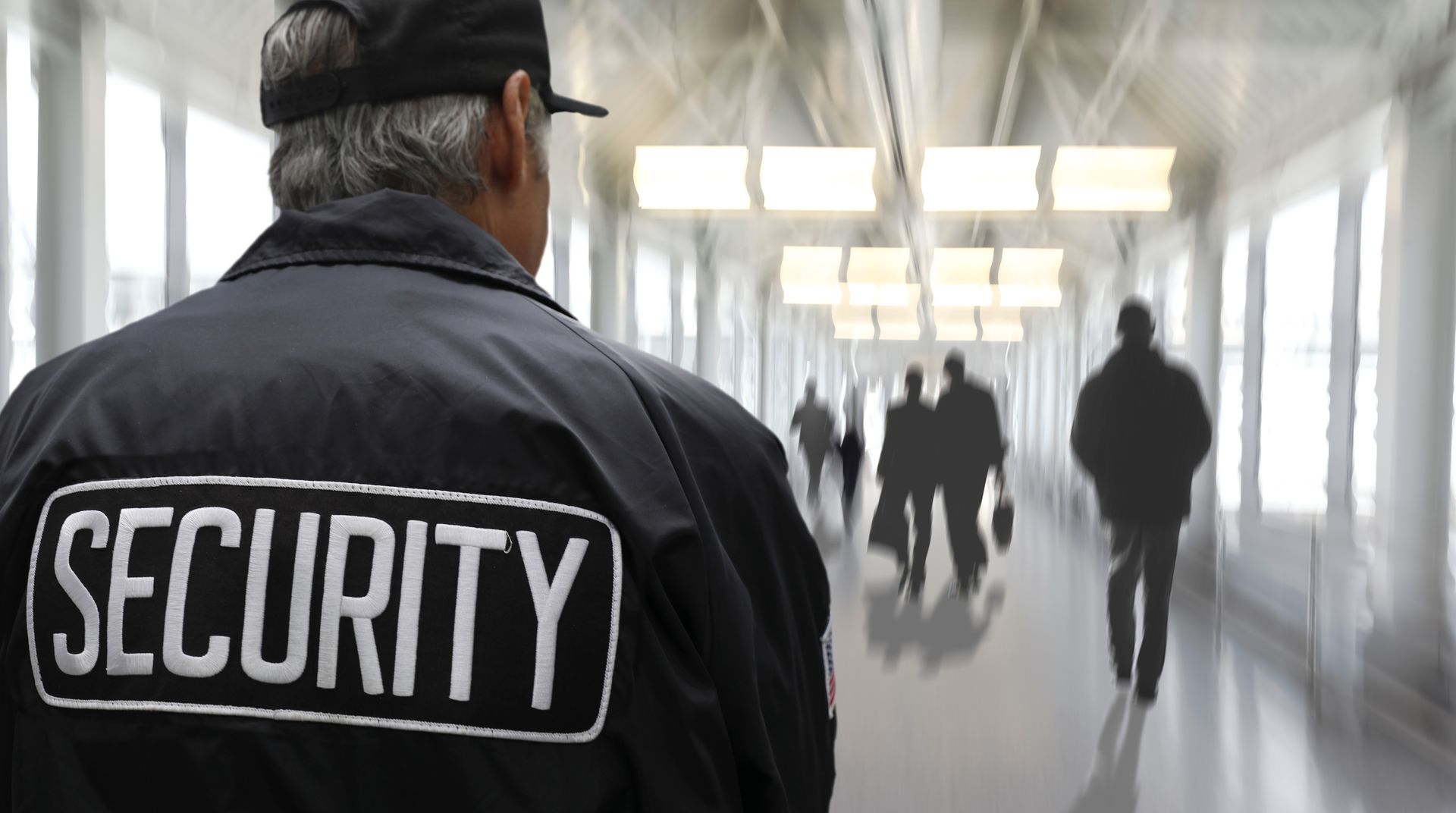 Security personnel in uniform standing near an entrance checkpoint.