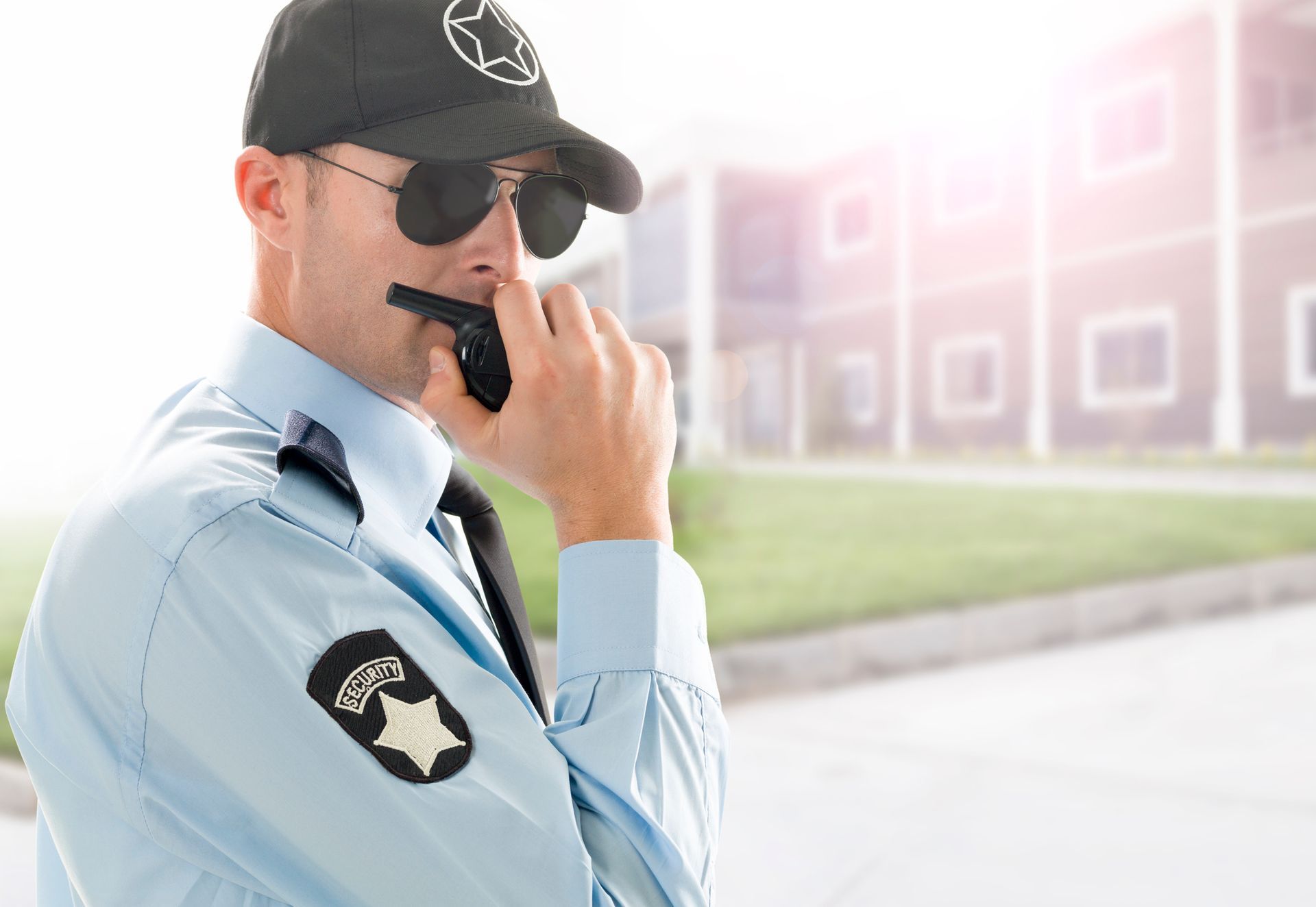 An unarmed security officer using a walkie-talkie in a public area, showing professionalism.