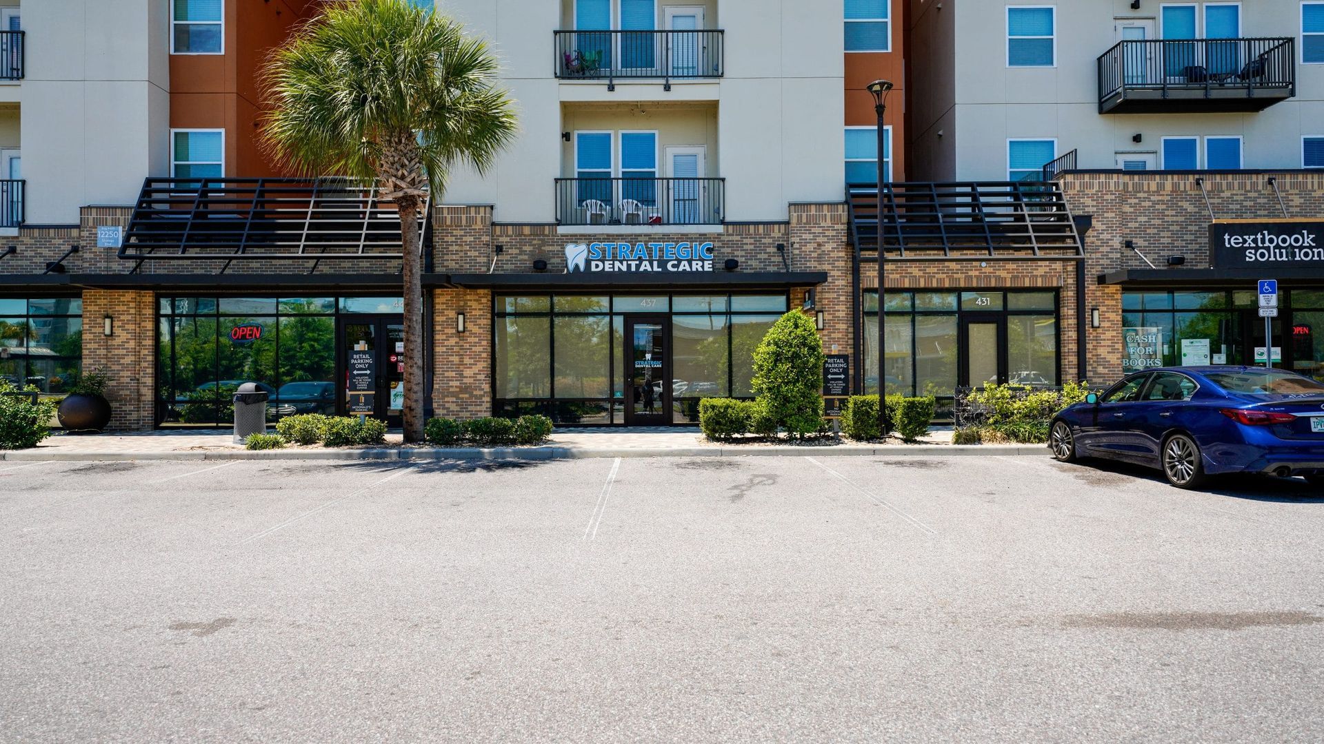 A blue car is parked in front of a building.