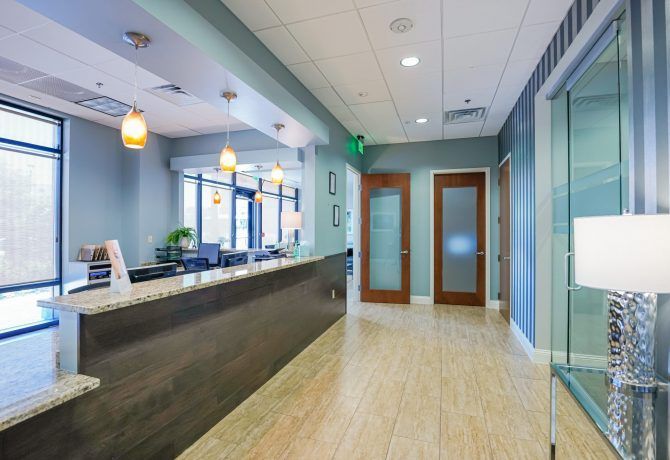 A long hallway with a reception desk in the middle of it
