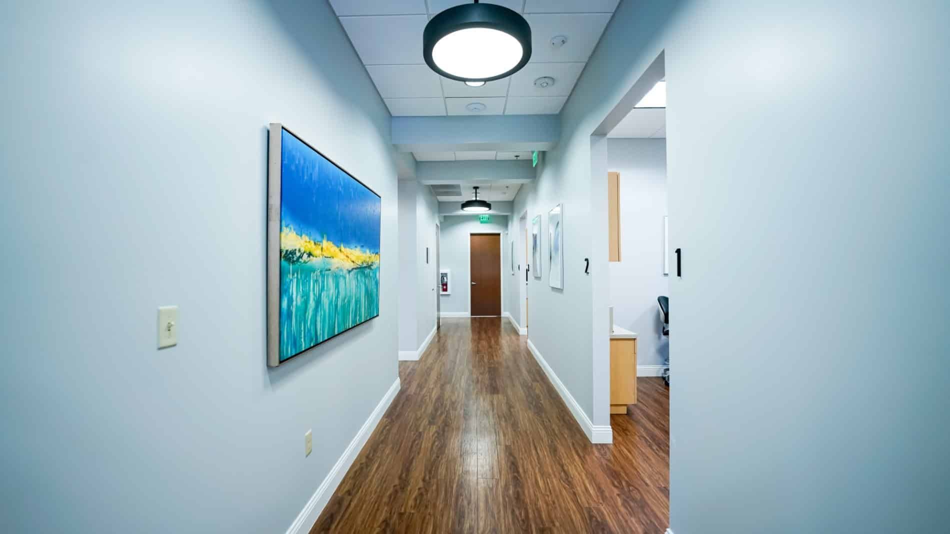 A long hallway with a painting on the wall.