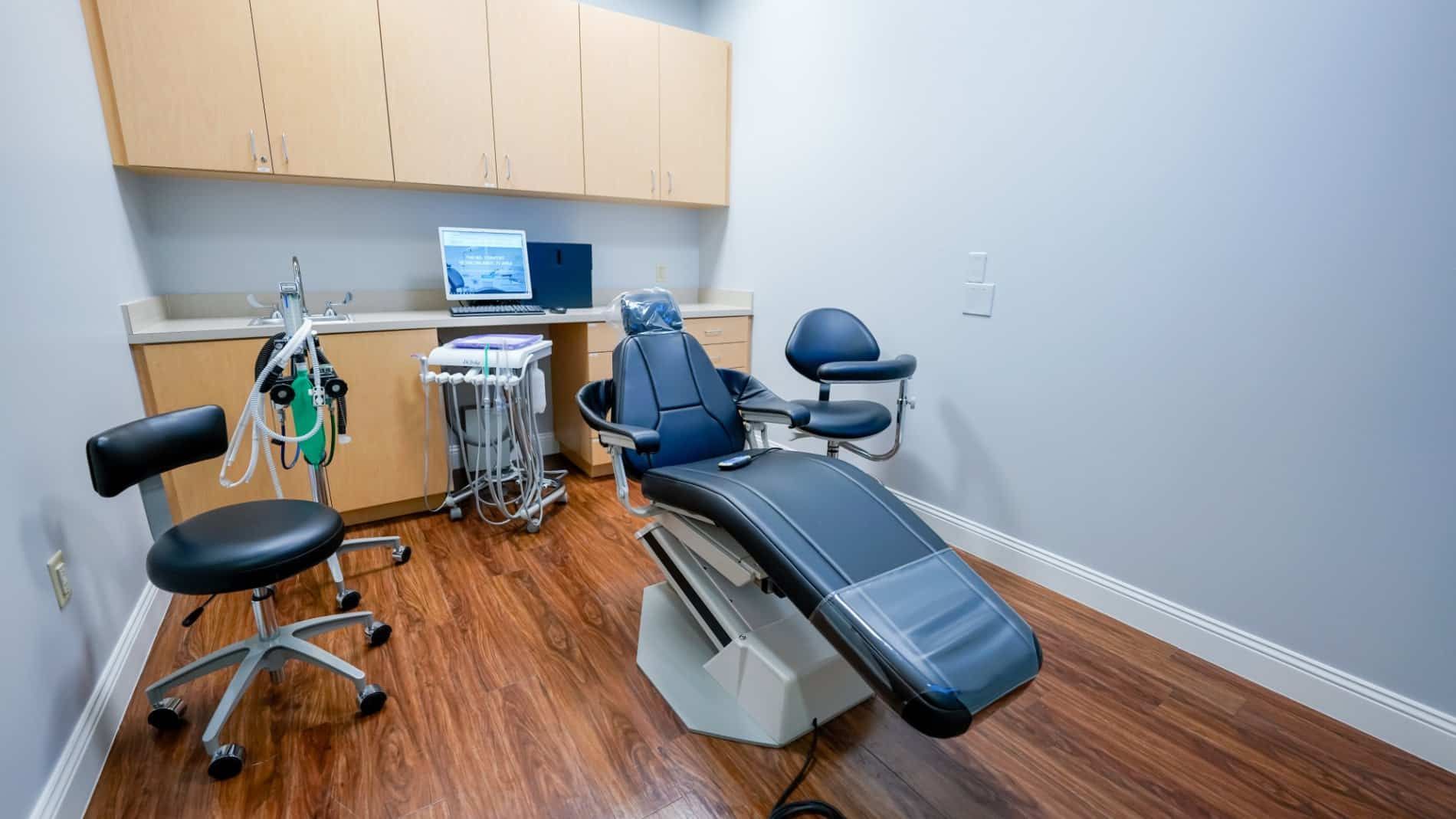 There is a dental chair in the middle of the room.