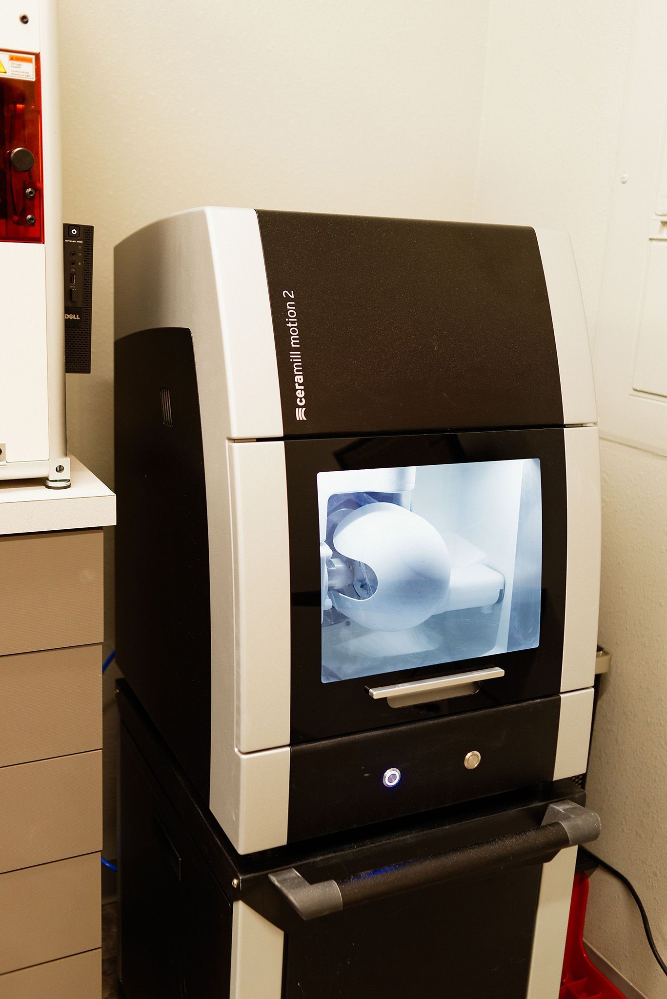 A black and white machine is sitting on a shelf in a room.