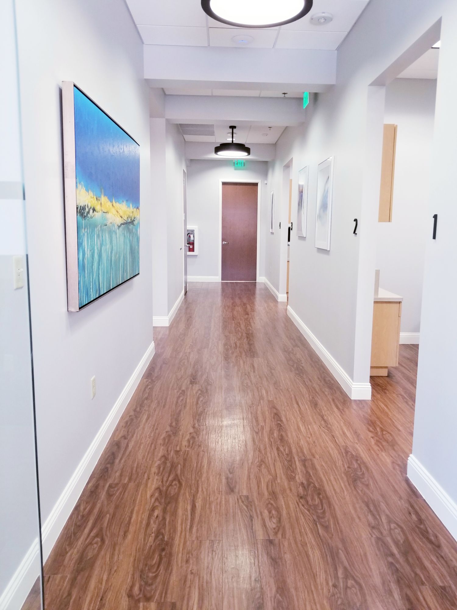 A long hallway with a painting on the wall