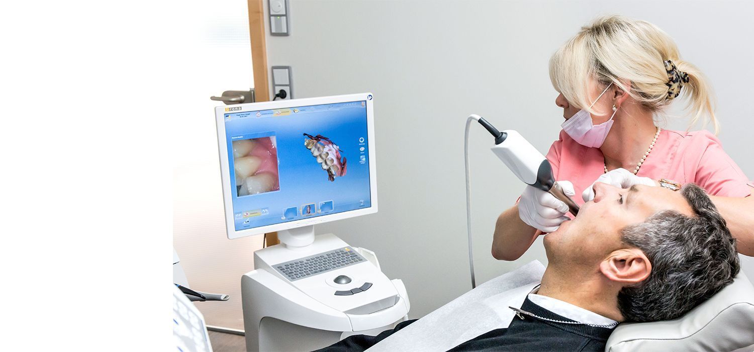 A man is getting his teeth examined by a dentist in a dental office.