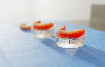A row of dentures sitting on top of a blue table.