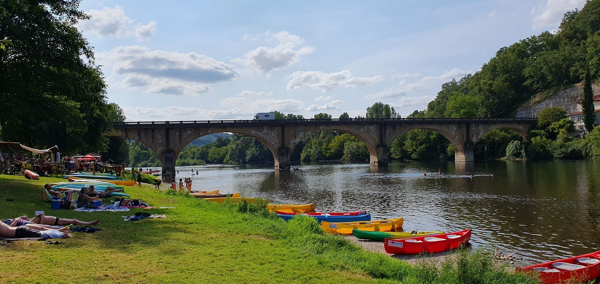 A bridge over a river with kayaks in the foreground