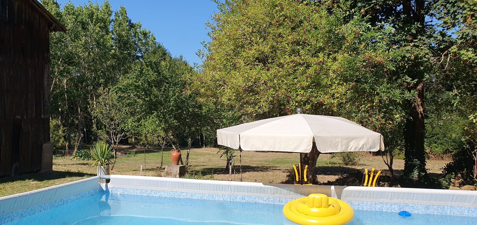 Een man zit op een bankje in het bos bij de rivier