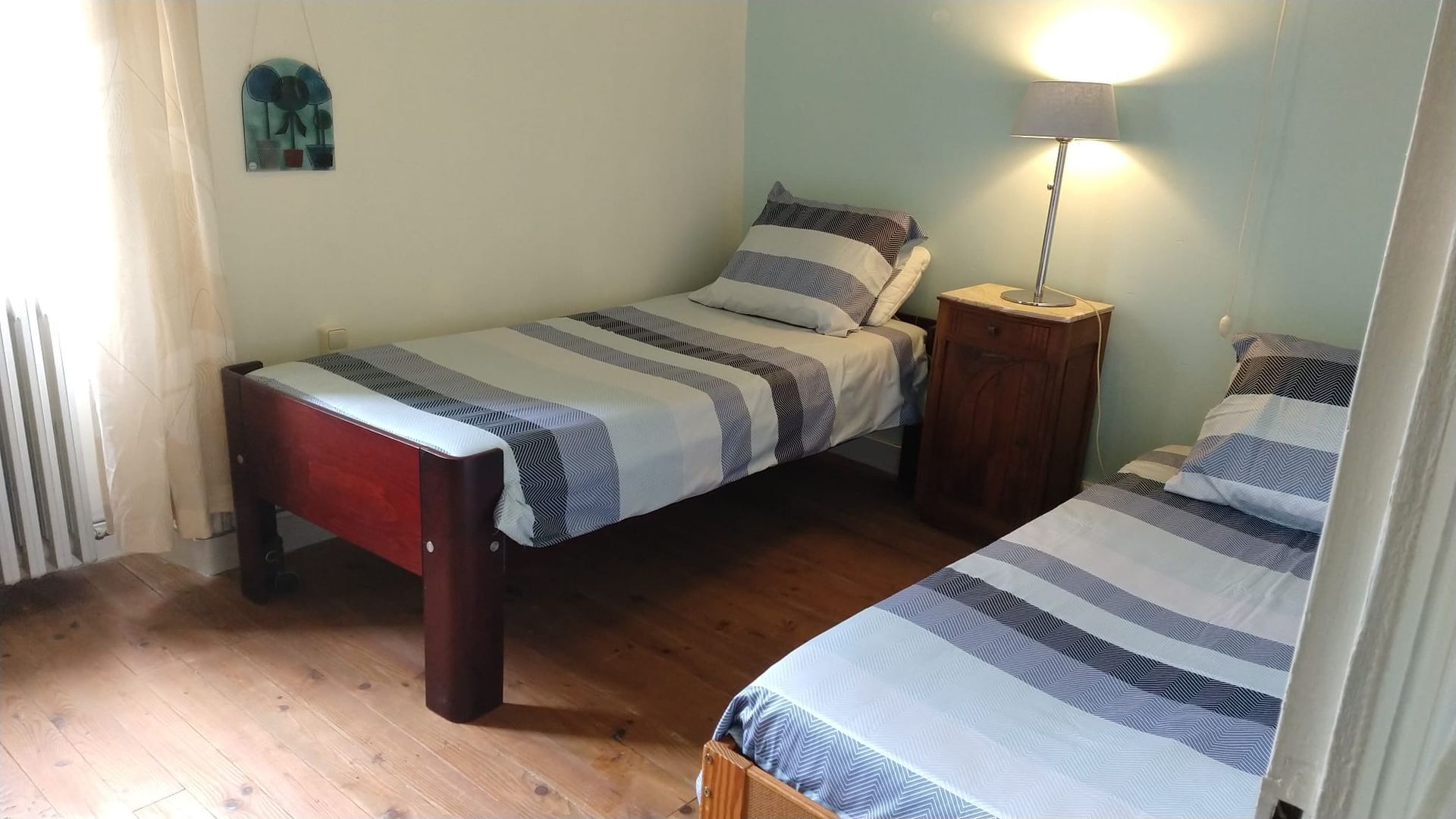 Een slaapkamer met twee eenpersoonsbedden en een nachtkastje