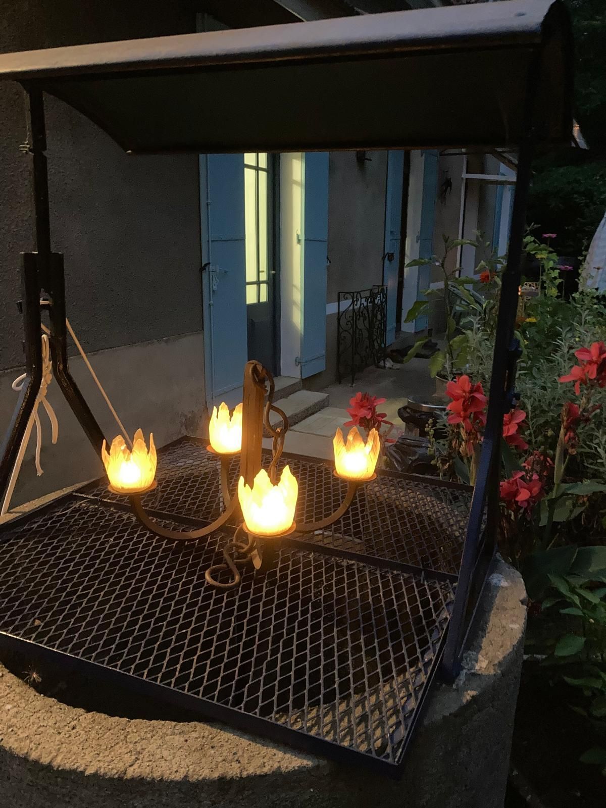 Een tafel met een vaas met bloemen en een fles wijn erop