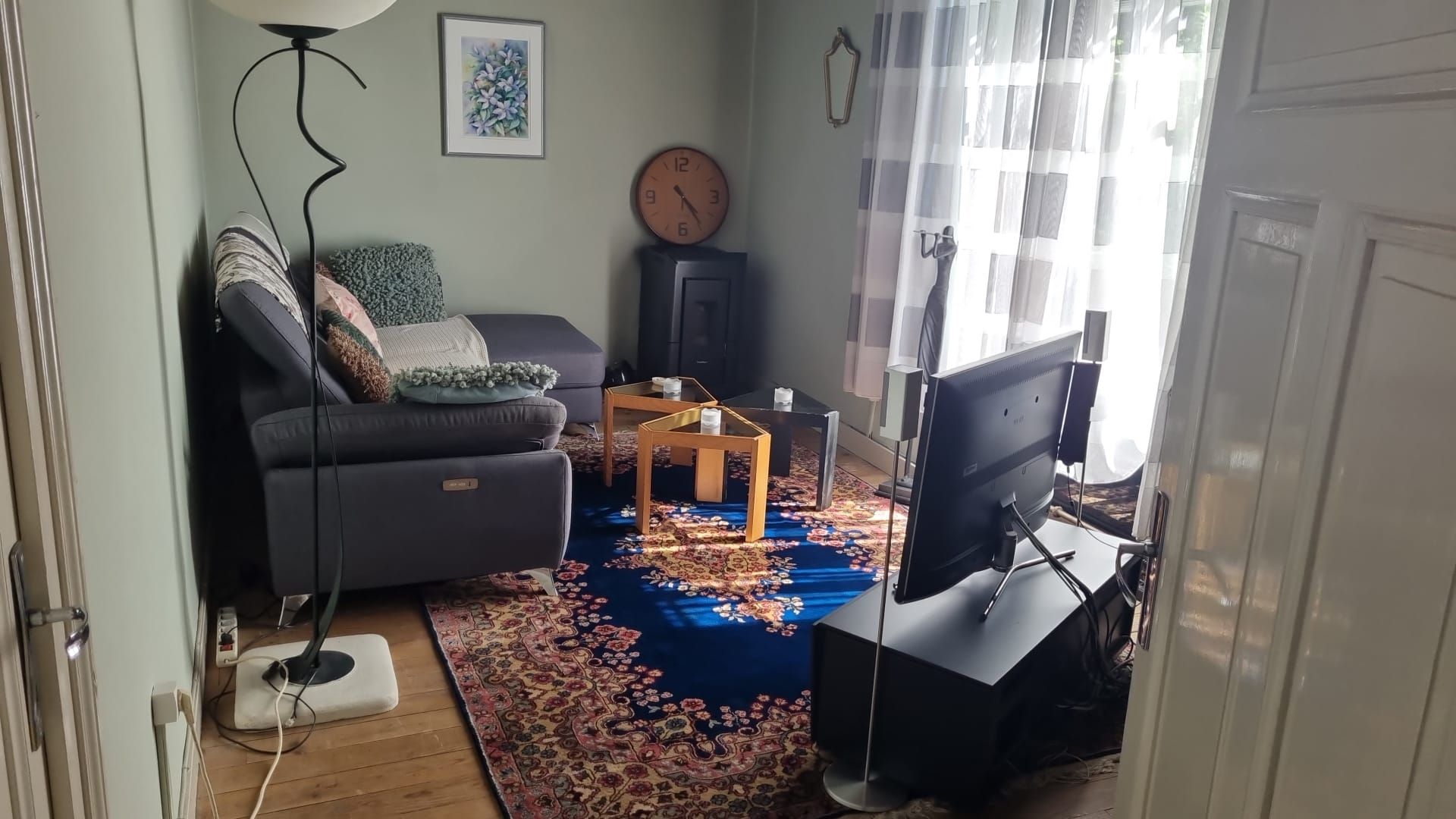 Een woonkamer met een bank, een tafel en een pelletkachel