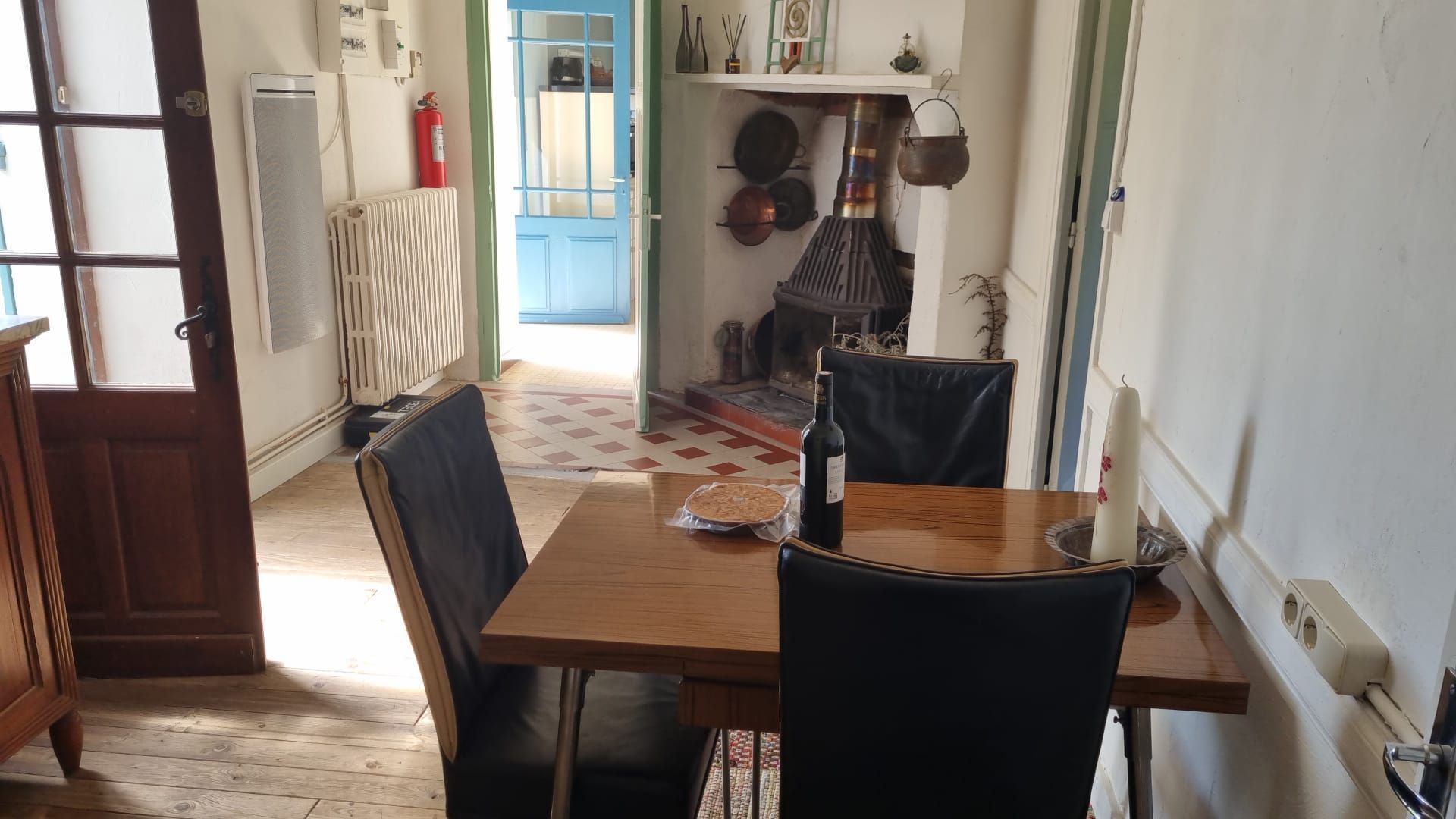 A room with a table and chairs and a butterfly on the wall