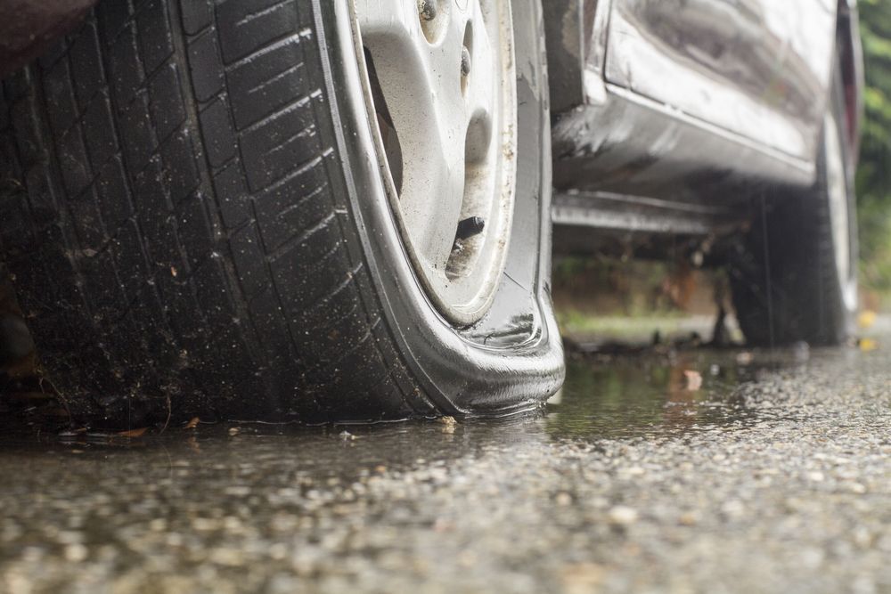 Close-up of  Flat Tyre on a Wet Road