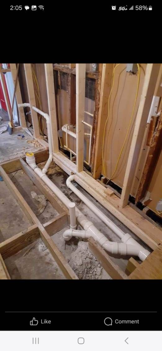 Bathroom construction with exposed framing and plumbing.