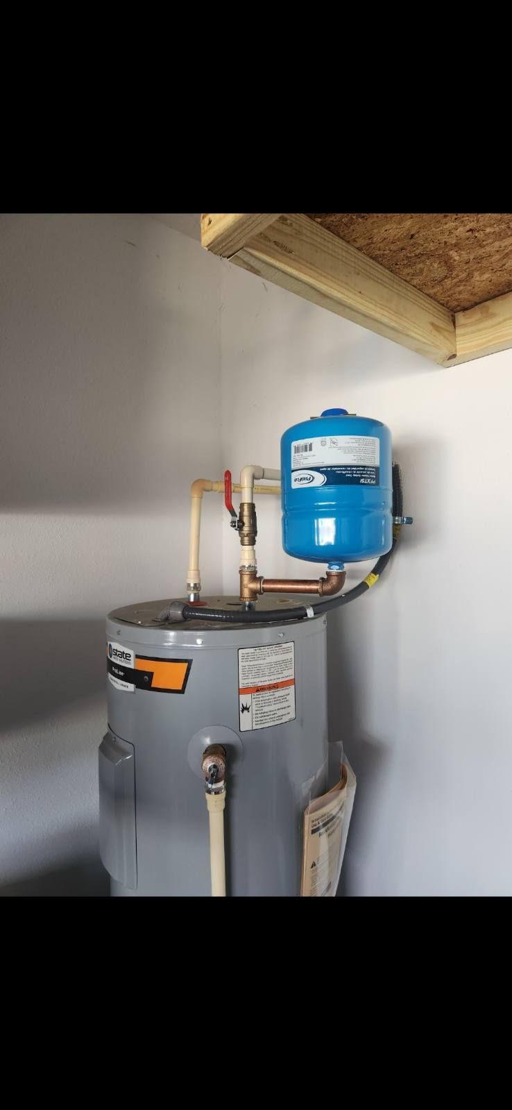 Water heater with expansion tank in a room.